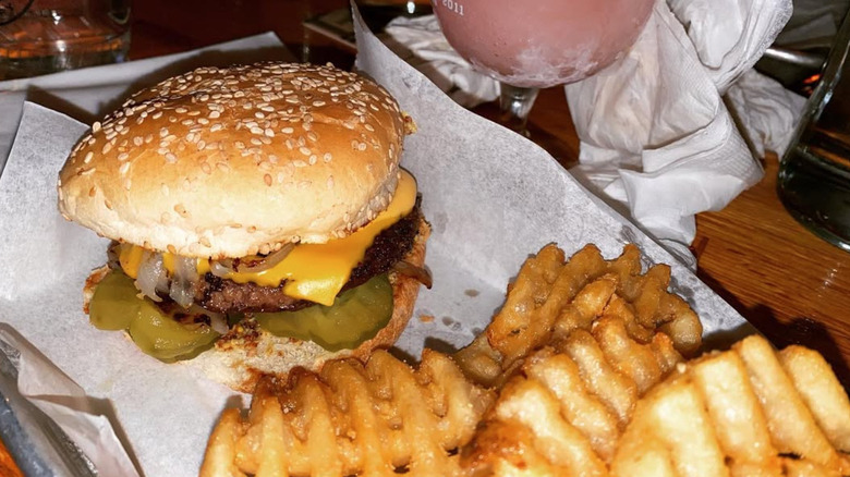 Burger with fries on tray with white parchment paper at The Avenue Bar