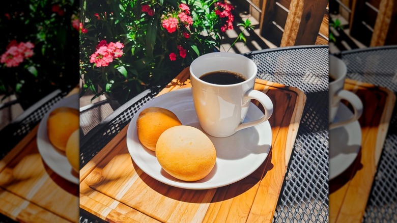 Cup of black coffee in a mug on a plate with Colombian pastries