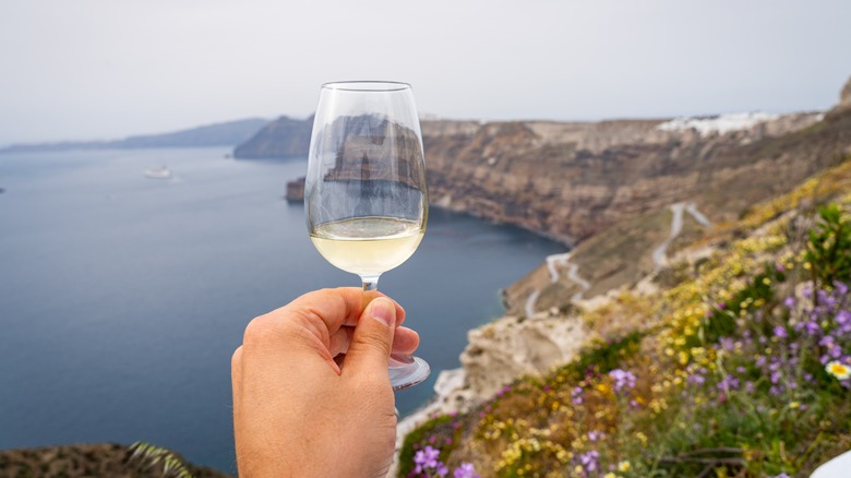 holding white wine in Santorini