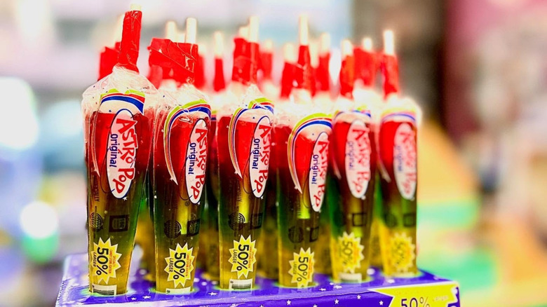 A box full of yellow, green, and red Astro Pops in their wrappers