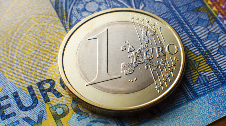 Close-up of one Euro coin on a 20 euro background