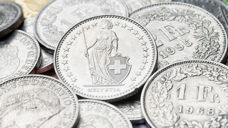 A collection of silver Swiss franc coins, with the back of 1 CHF in the center