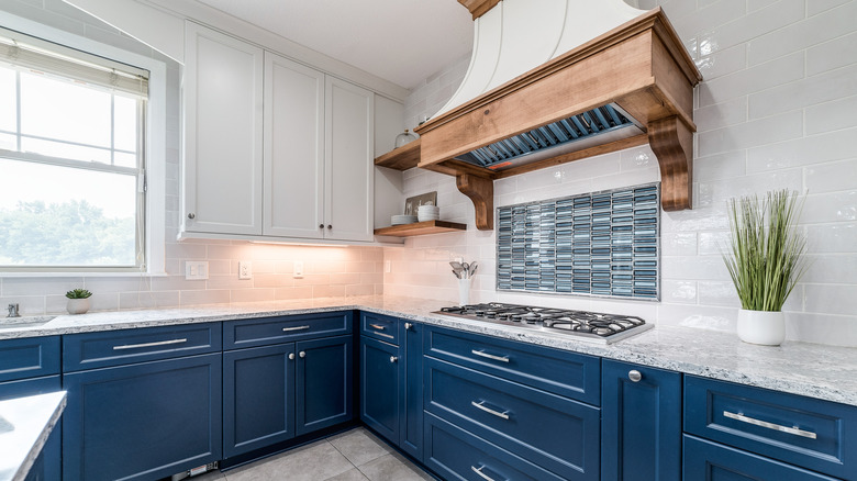 dark blue kitchen cabinets with white and gray countertops