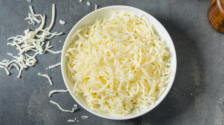 Overhead shot of bowl of shredded mozzarella cheese.