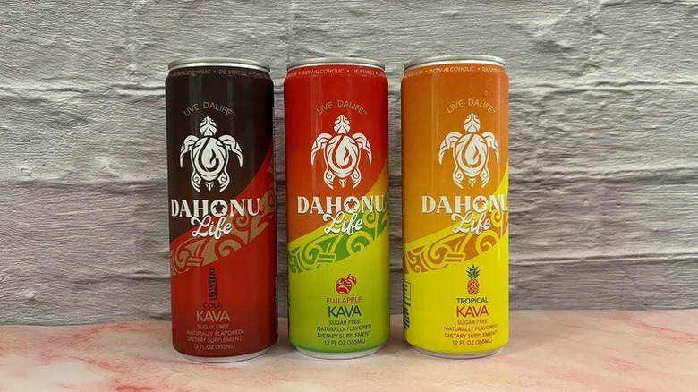 Three cans of DaHonu Life stacked next to each other in front of a white wall