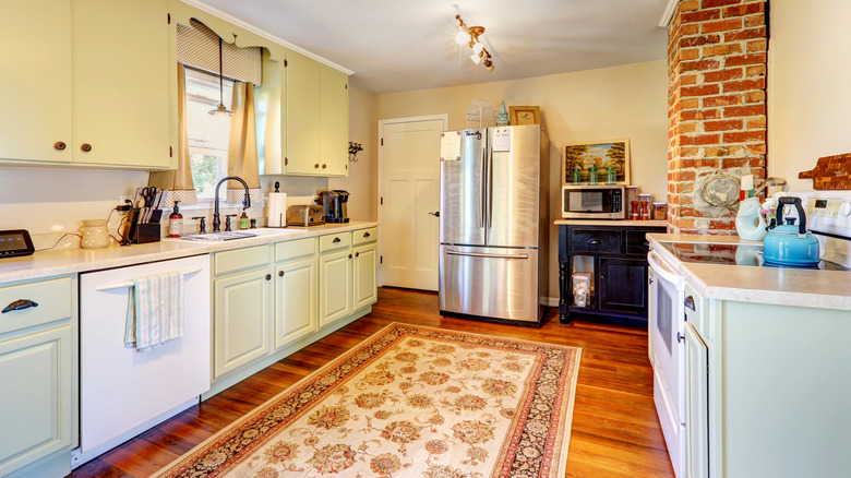 Quaint kitchen with a large area rug in the center of the floor