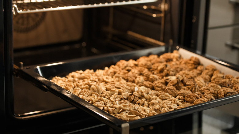 walnuts on metal baking tray going into oven