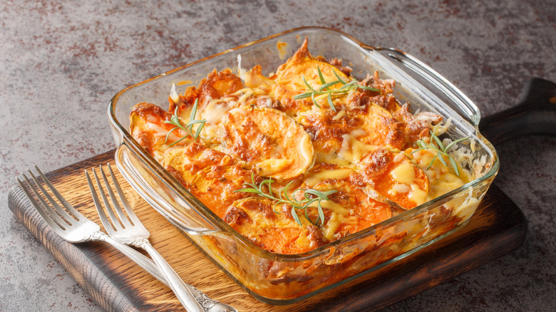 sweet potato gratin in glass baking dish on cutting board