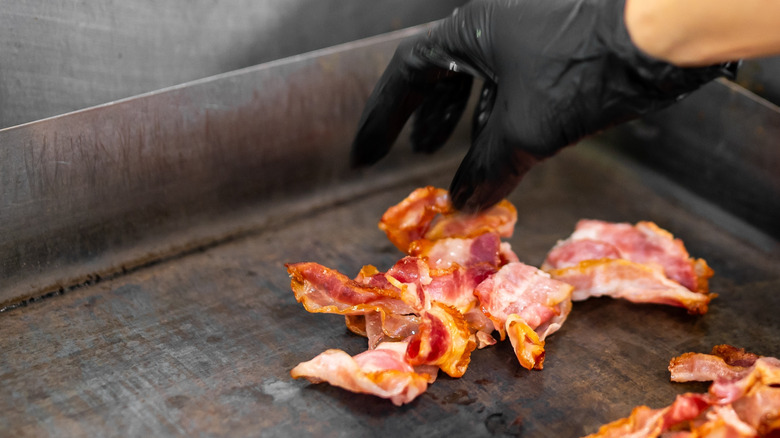 someone cooking bacon in restaurant