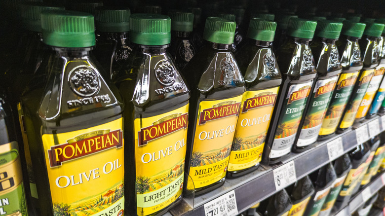 Closeup of bottles of olive oil on a grocery store shelf