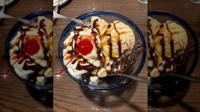 Red Lobster Brownie Overboard in a glass dish with spoons on a wooden table, with mirror borders