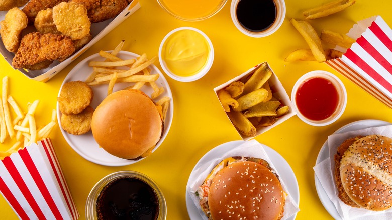 Various fast food items shown from aerial view on yellow table