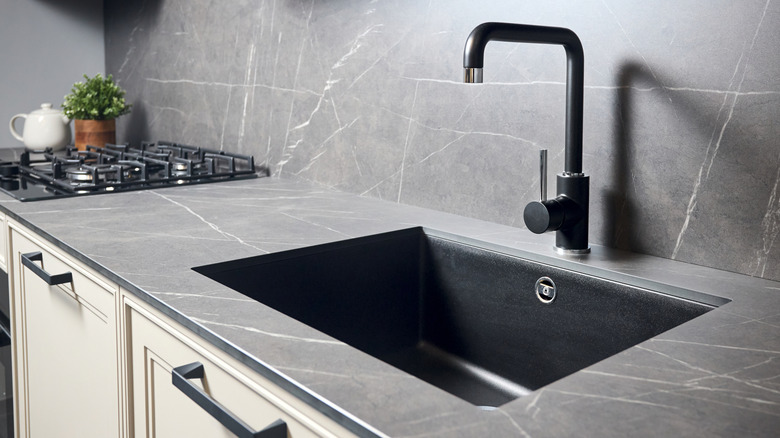 Modern kitchen with a black sink and pipe