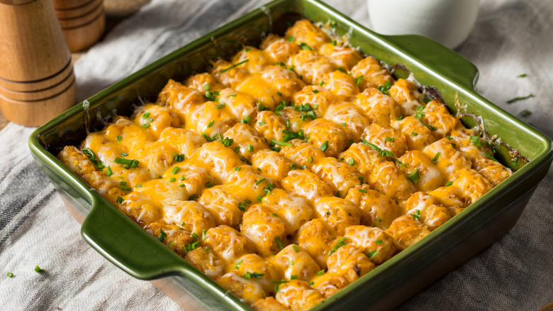 cheesy tater tot hotdish in a green ceramic pan
