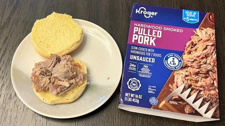 Kroger Hardwood Smoked Pulled Pork box next to open bun with meat on top.
