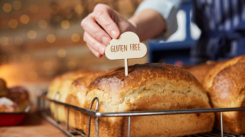 A person putting a gluten free bread on display at restaurant bakery