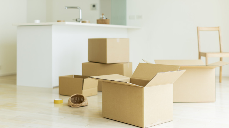 Several cardboard boxes placed in a bright and airy kitchen