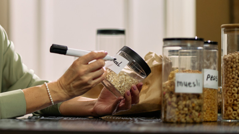 A woman labeling food storage containers with a marker