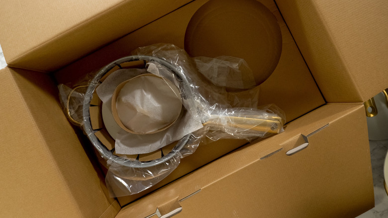 Several pots placed together in a cardboard box with packing materials