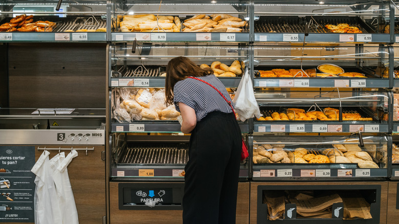 woman at Aldi bakery picking up bread
