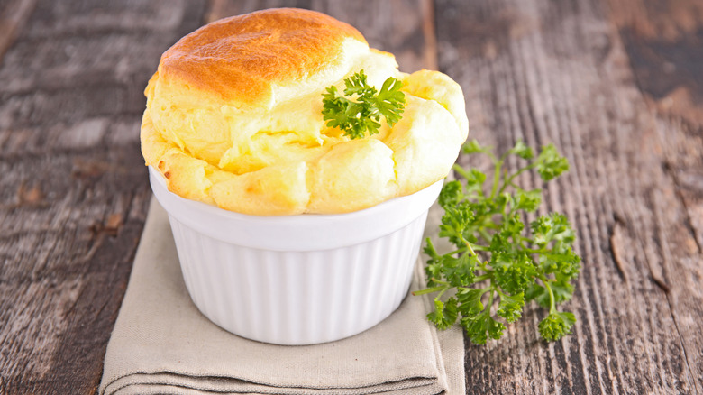 cheesy souffle in a white ramekin with parsely garnish