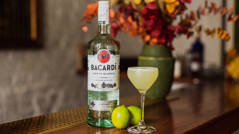 Bottle of Bacardi rum with cocktail on bar