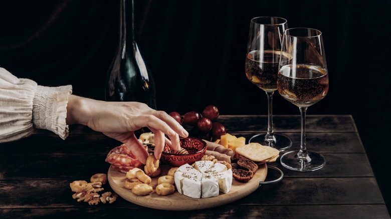 hand reaching for charcuterie board 