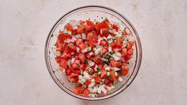 mixing pico de gallo in a bowl