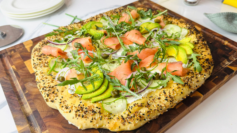 Bagels and lox inspired pizza on wooden board