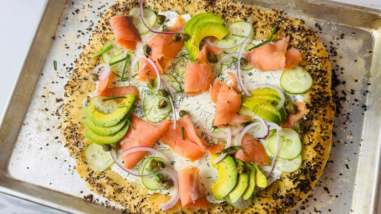 Bagels and lox inspired pizza on baking sheet