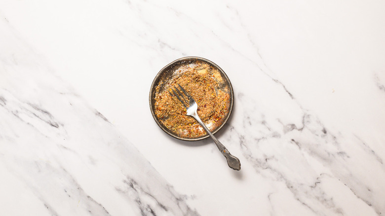 Mixed spices in small plate with fork.