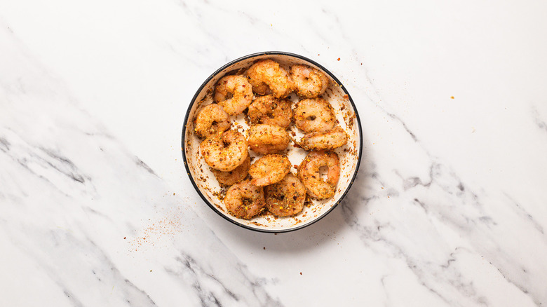 Shrimp in mixed spices in bowl.