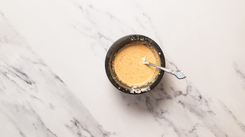 Sauce in mortar with fork.