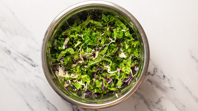 Salad greens in large bowl.