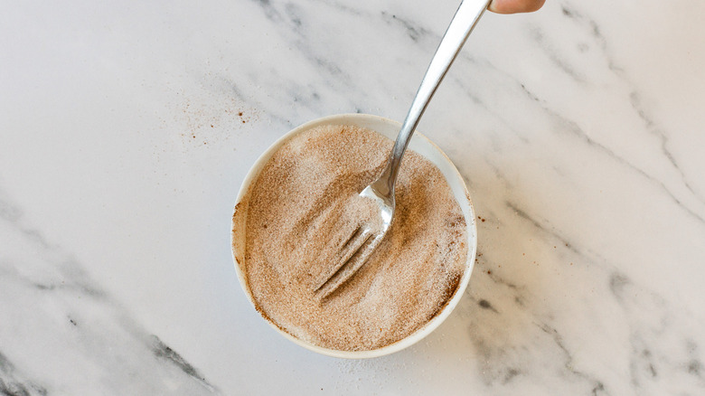 Whisking cinnamon sugar in bowl.
