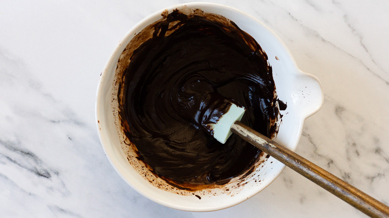 Chocolate sauce in bowl with spatula.
