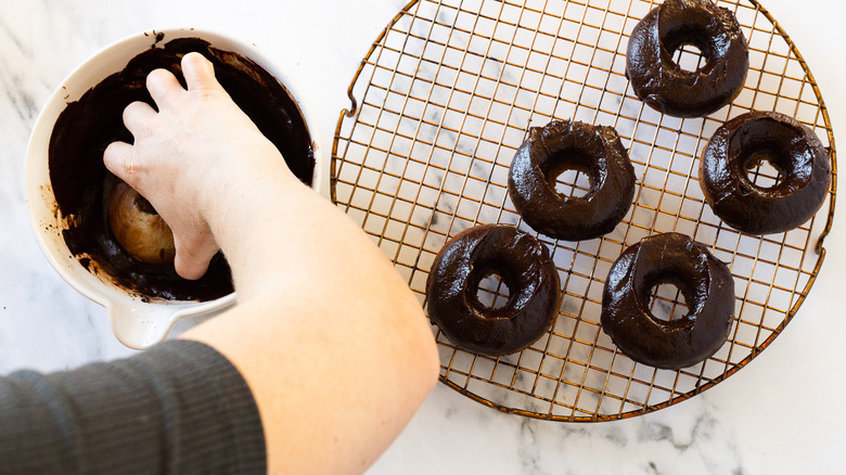 Dipping donuts into chocolate sauce.
