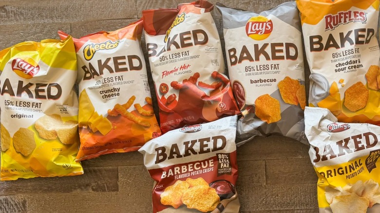 Nine bags of different baked potato chips on wooden table