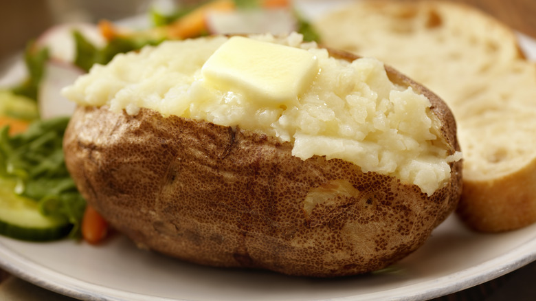 Baked potato on plate with butter