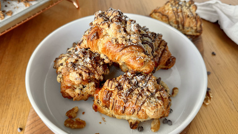 Pile of chocolate chip cookie-stuffed croissants on a plate