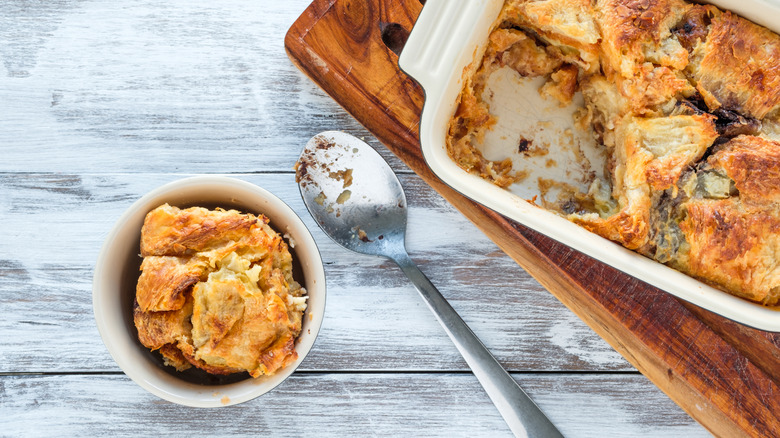 Croissant bread pudding served from a baking dish into a bowl