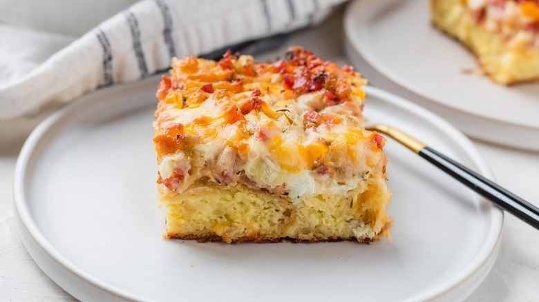 Portion of cheesy croissant breakfast casserole on a plate