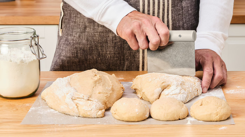 A person cutting dough with the Lättbakad dough cutter