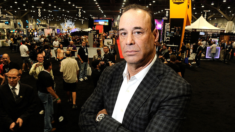 Jon Taffer with his arms crossed posing for a photo at a convention of some sort