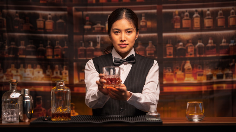Bartender presenting drink behind bar
