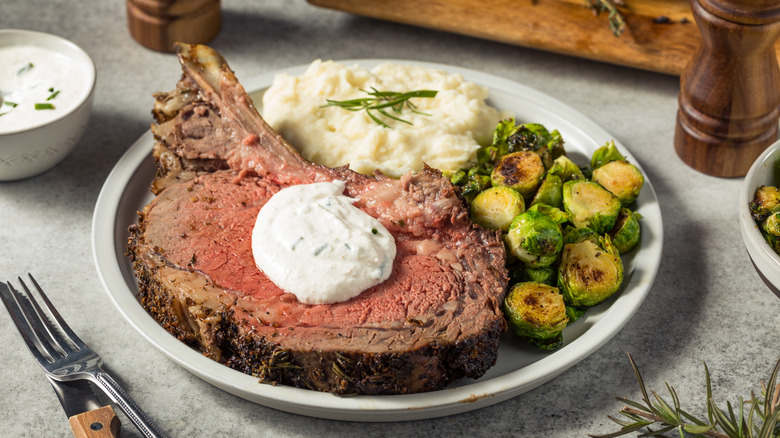 sliced smoked prime rib with horseradish sauce, mashed potatoes, and Brussels sprouts