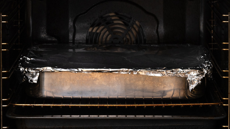 Foil-covered pan in oven