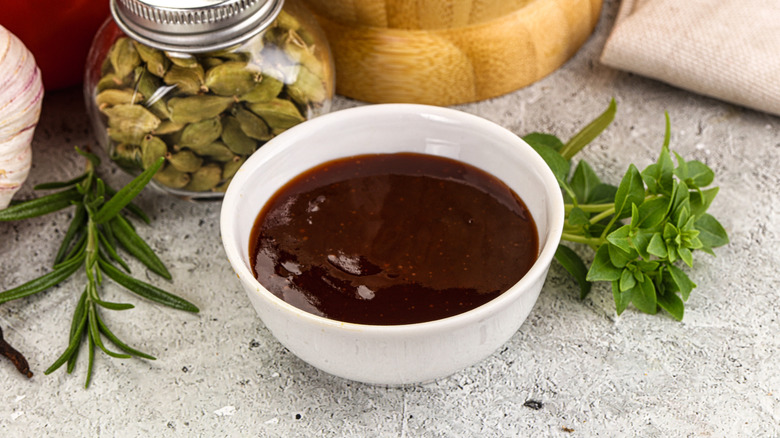 Barbecue sauce in a dish with herbs