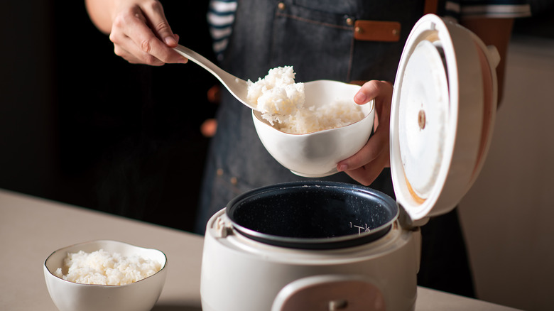 Scooping cooked rice into bowl