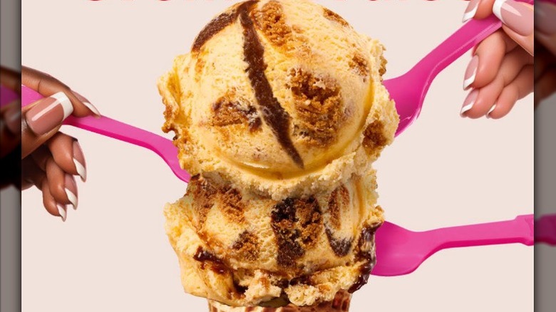 A shot of two scoops of Baskin-Robbins Biscoff Crème Brûlée Ice Cream on a cone with two hands and three spoons